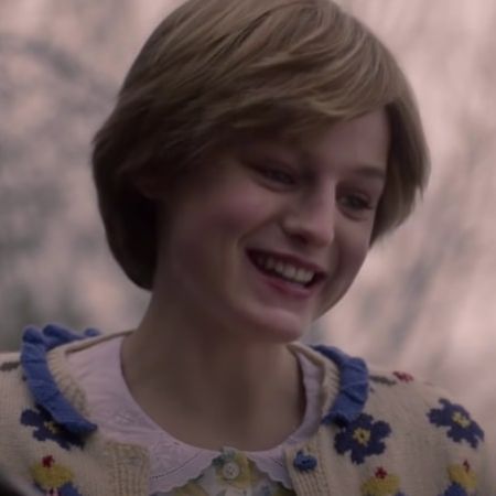 Emma Corrin has a short hair as she is smiling.